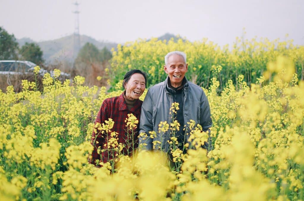 Happy senior couple outside in a field of flowers